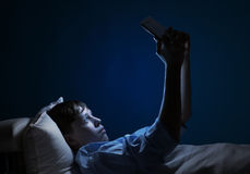 reading-bed-young-teenager-guy-using-tablet-pc-48140940